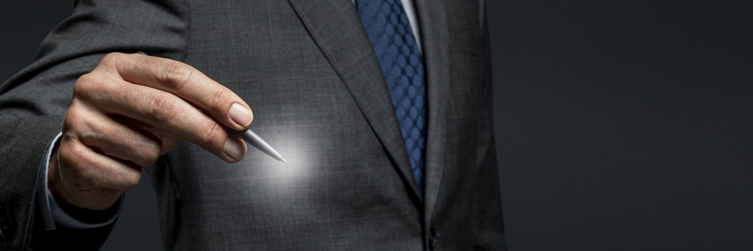 Businessman using a pen and signing on an invisible screen